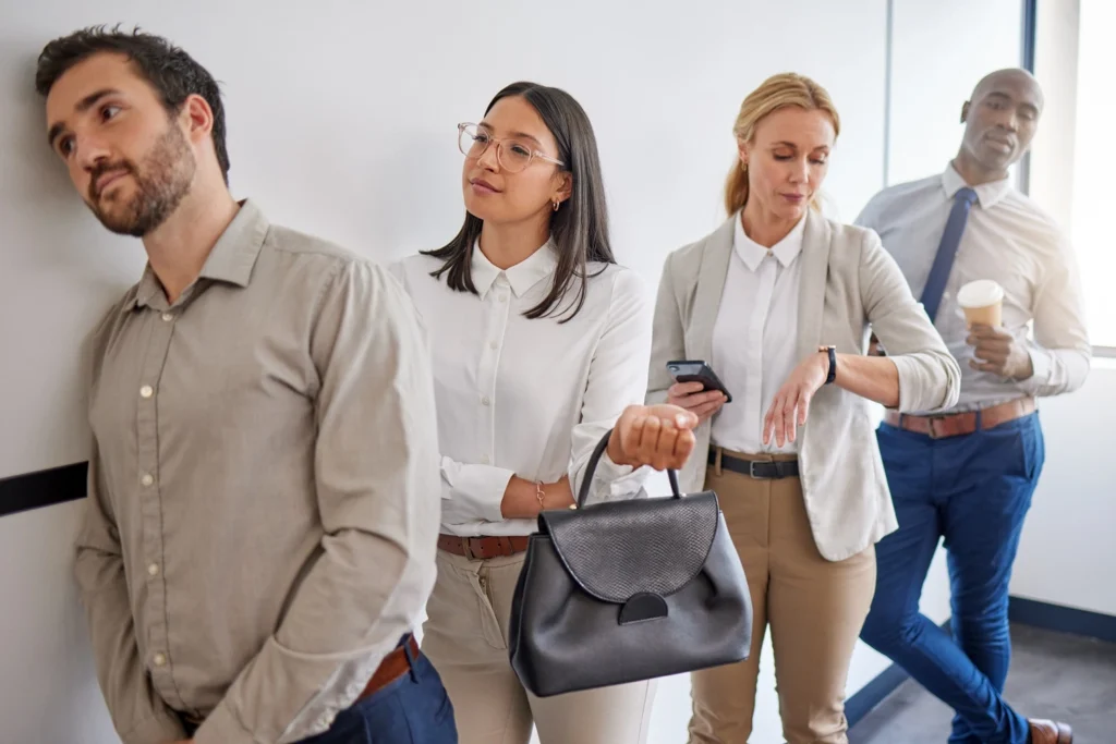 Office staff waiting in a coffee queue during a busy break.